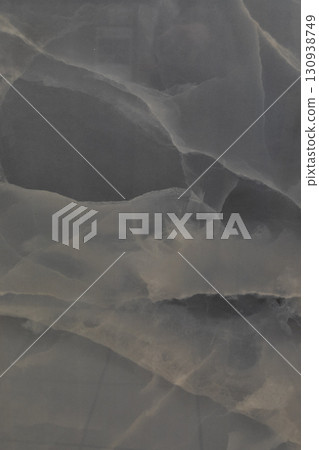 Textured gray surface with intricate patterns resembling waves and ripples in rock formation Textured gray surface with intricate patterns resembling waves and ripples in rock formation 130938749