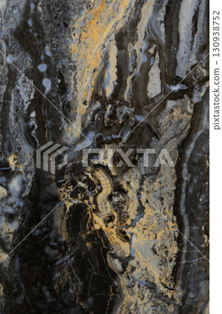 Dark stone surface with unique swirling patterns and hues of gold, gray, and black created by 130938752
