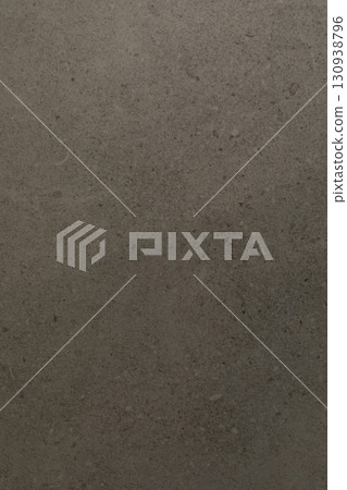 Gray textured surface with subtle variations reflecting light in an indoor setting 130938796