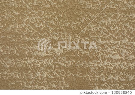 Textured wall surface with a warm beige tone showcasing intricate patterns in natural light Textured wall surface with a warm beige tone showcasing intricate patterns in natural light 130938840