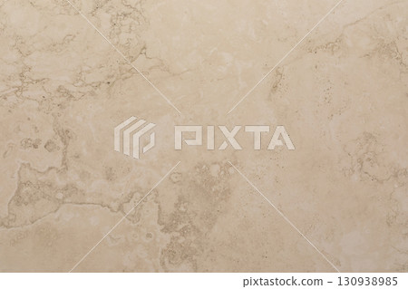 Surface of light beige natural stone with subtle patterns and texture showcasing its unique features 130938985