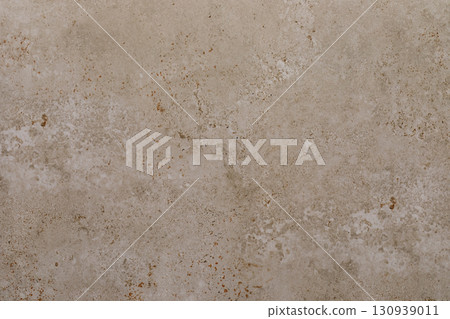 Surface of textured beige concrete with subtle patterns and imperfections showing natural wear and 130939011