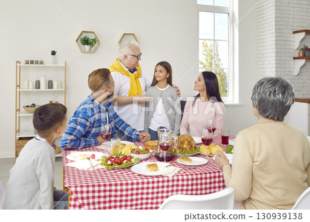 Happy young and senior family members meet on holiday and have dinner all together Happy young and senior family members meet on holiday and have dinner all together 130939138