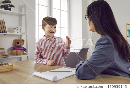 Female speech therapist with a little boy patient practicing private development lesson. 130939143