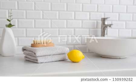Minimalist bathroom counter with lemon brush and folded towel 130939282