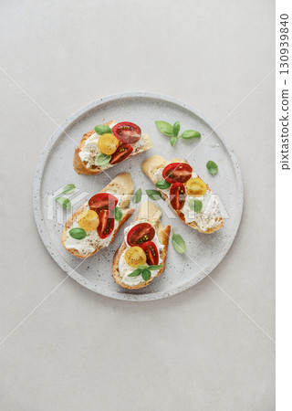 Bruschetta sandwiches with tomatoes, cream cheese, olive oil and basil Bruschetta sandwiches with tomatoes, cream cheese, olive oil and basil 130939840