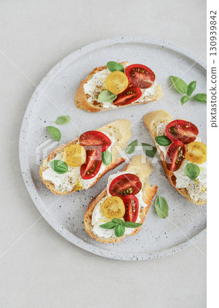 Bruschetta sandwiches with tomatoes, cream cheese, olive oil and basil Bruschetta sandwiches with tomatoes, cream cheese, olive oil and basil 130939842