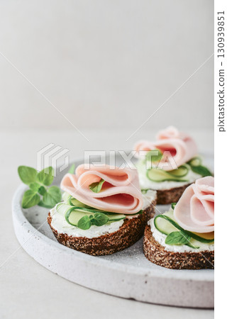 Bruschetta with baguette, bacon or meat, cream cheese, oregano and fresh cucumber Bruschetta with baguette, bacon or meat, cream cheese, oregano and fresh cucumber 130939851
