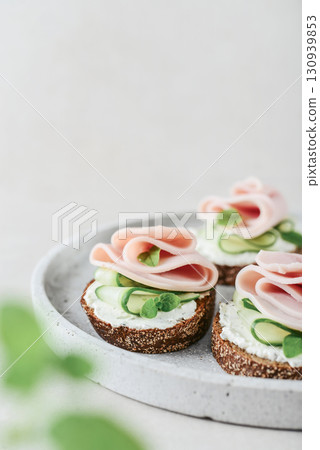 Bruschetta with baguette, bacon or meat, cream cheese, oregano and fresh cucumber 130939853