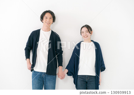 Couple standing side by side holding hands Couple standing side by side holding hands 130939913