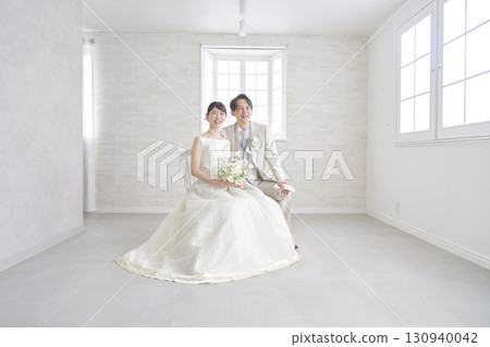 Bride and groom portrait looking at camera full body 130940042