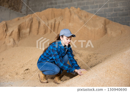 Farmer holding a handful of soybean husks in an animal feed warehouse Farmer holding a handful of soybean husks in an animal feed warehouse 130940690