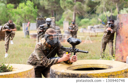 Portrait of girl in camouflage on paintball field Portrait of girl in camouflage on paintball field 130940746