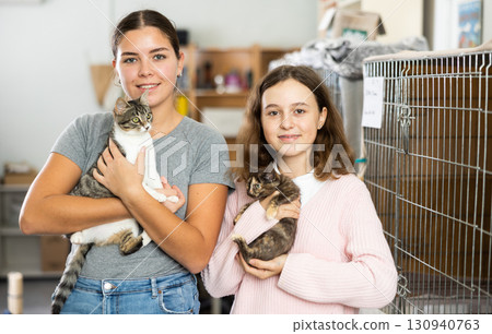 Preteen girl and female volunteer of animal shelter holding kittens Preteen girl and female volunteer of animal shelter holding kittens 130940763