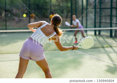 European woman tennis player in padel tennis playing on the outdoor court European woman tennis player in padel tennis playing on the outdoor court 130940804