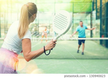 European woman tennis player in padel tennis playing on the outdoor court European woman tennis player in padel tennis playing on the outdoor court 130940823