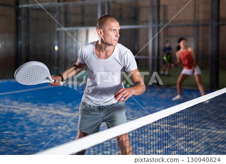 Male player ready to hits the ball while playing padel 130940824
