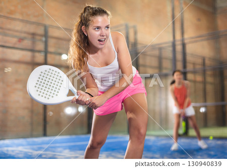 Emotional young sportswoman playing padel tennis on indoor court Emotional young sportswoman playing padel tennis on indoor court 130940839