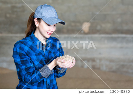 Female farmer holding handful of organic granulated feed for calves Female farmer holding handful of organic granulated feed for calves 130940880