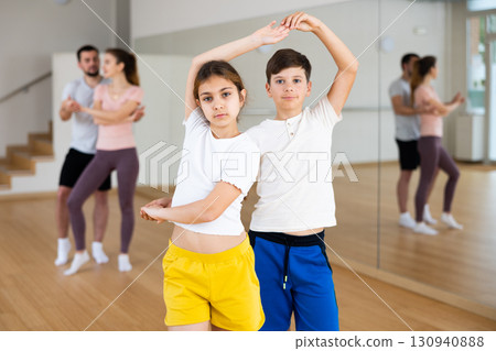 Siblings practicing active dance in pairs 130940888
