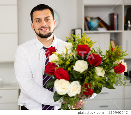 Businessman in office with bunch of flowers Businessman in office with bunch of flowers 130940942