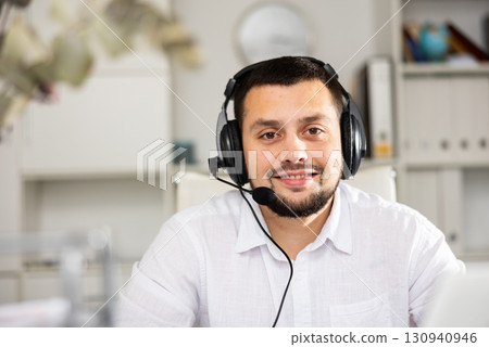 Portrait of positive man office worker wearing headset Portrait of positive man office worker wearing headset 130940946