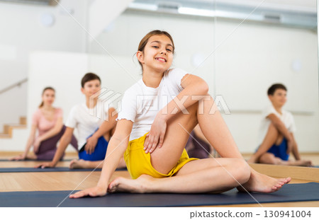 Girl doing lord of the fishes pose in gym Girl doing lord of the fishes pose in gym 130941004