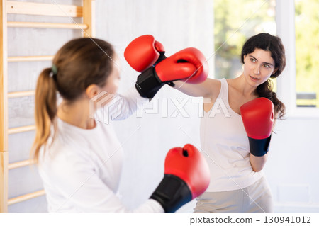 Two women training boxing fight in studio 130941012