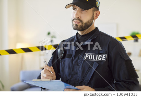 Police officer is actively engaged in documenting information at crime location. Police officer is actively engaged in documenting information at crime location. 130941013
