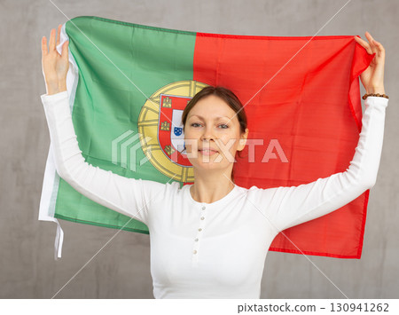 Adult cheerful woman holding Portugal flag 130941262