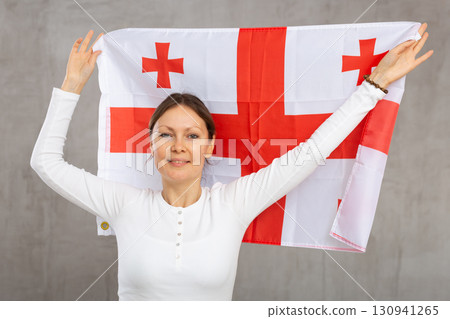 Happy smiling woman proudly displaying georgian flag Happy smiling woman proudly displaying georgian flag 130941265