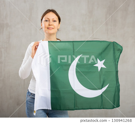 Happy smiling woman proudly displaying pakistani flag Happy smiling woman proudly displaying pakistani flag 130941268