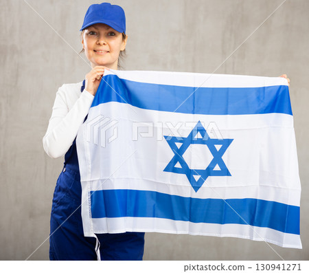 Smiling adult woman in uniform holding Israel flag Smiling adult woman in uniform holding Israel flag 130941271