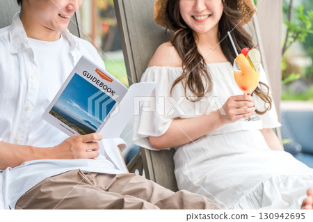 一對夫婦在旅行中坐在度假酒店的池畔椅上 一對夫婦在旅行中坐在度假酒店的池畔椅上 130942695