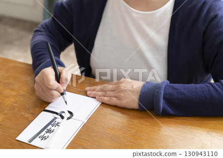 一位老年婦女用毛筆在弔唁信封上寫地址 130943110