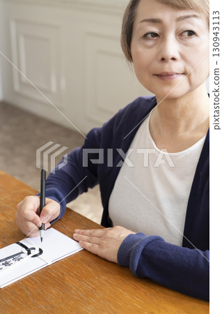 一位老年婦女用毛筆在弔唁信封上寫地址 一位老年婦女用毛筆在弔唁信封上寫地址 130943113