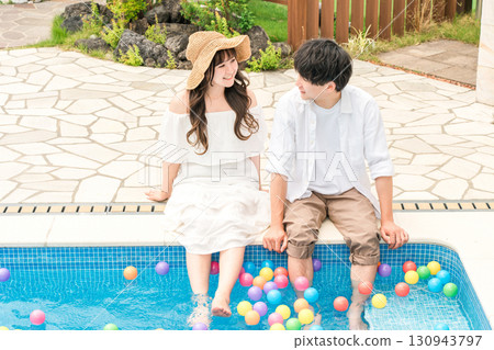 Couple playing by the pool at a resort hotel on a trip Couple playing by the pool at a resort hotel on a trip 130943797