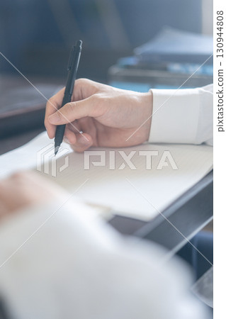 Hand holding a pen 130944808