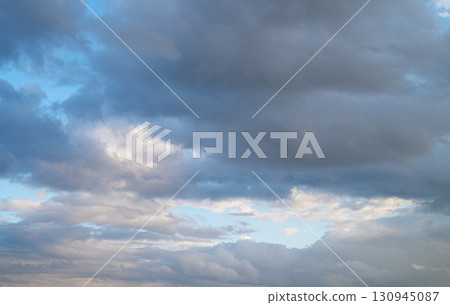 Clouds dance across the expansive sky during a vibrant evening in a tranquil 130945087