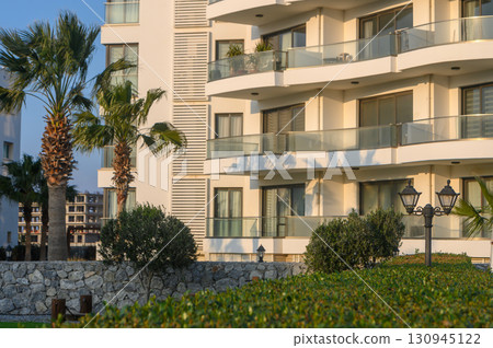 Modern architecture showcases luxury living by the coastal palm trees at sunset in a serene urban landscape 130945122