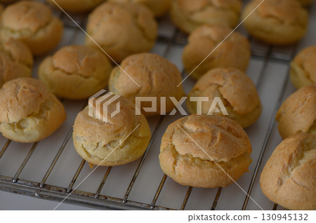Freshly baked golden pastries cooling on a wire rack in a cozy kitchen setting Freshly baked golden pastries cooling on a wire rack in a cozy kitchen setting 130945132