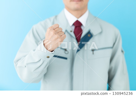 A middle-aged male businessman in work clothes making a fist pump 130945236
