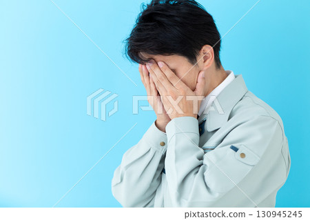 一位身穿工作服的中年男性商人,憂心忡忡,摀著臉 一位身穿工作服的中年男性商人,憂心忡忡,摀著臉 130945245