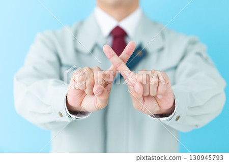 A middle-aged male businessman in work clothes making a cross sign A middle-aged male businessman in work clothes making a cross sign 130945793