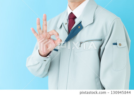 A middle-aged male businessman in work clothes making a circle sign A middle-aged male businessman in work clothes making a circle sign 130945844