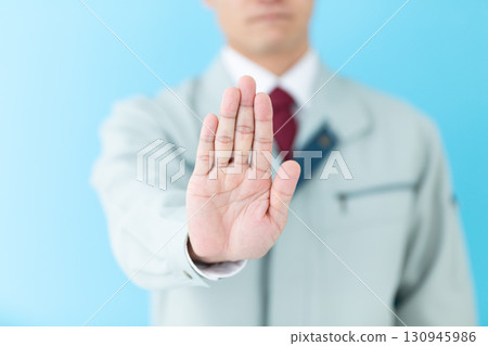 A middle-aged male businessman in work clothes making a refusal pose 130945986