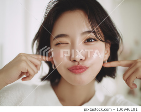 十幾歲的女孩用頑皮的表情指著自己的臉頰 十幾歲的女孩用頑皮的表情指著自己的臉頰 130946191