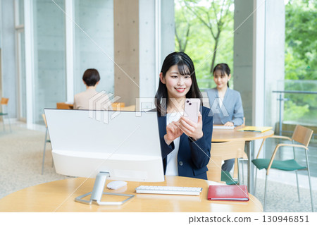 Business woman operating a smartphone in the office Business woman operating a smartphone in the office 130946851