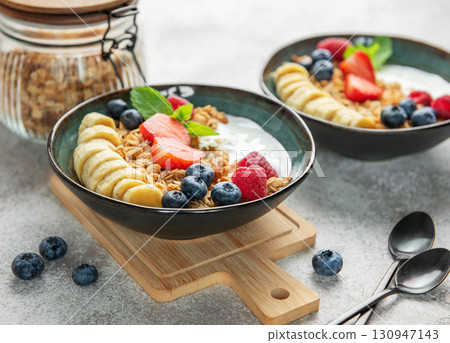Healthy breakfast bowls with yogurt, granola, berries and banana slices Healthy breakfast bowls with yogurt, granola, berries and banana slices 130947143