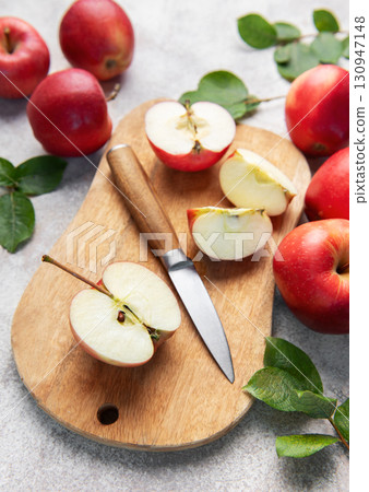 Fresh red apples and slices with knife on wooden cutting board 130947148